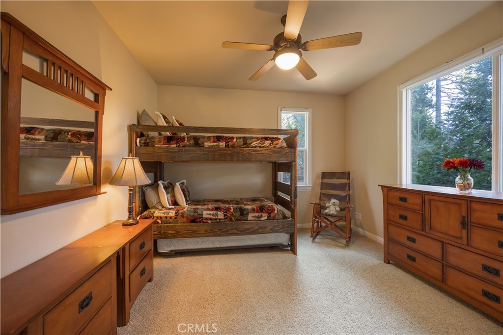 173 Grizzly Road Lake Arrowhead, CA 92352 - Photo 37 of 40 a bedroom with a bed and a chandelier