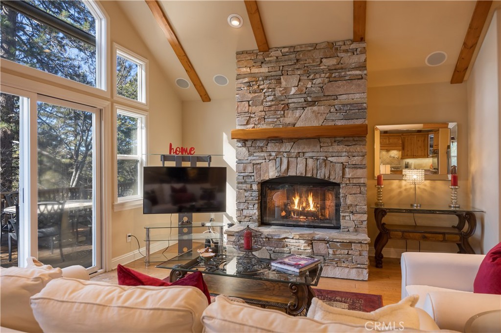 173 Grizzly Road Lake Arrowhead, CA 92352 - Photo 7 of 40 a living room with furniture a fireplace a flat screen tv and a floor to ceiling window