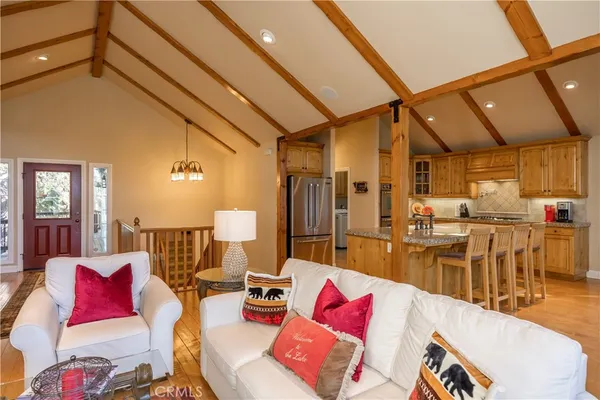 a living room with furniture and a dining table with wooden floor