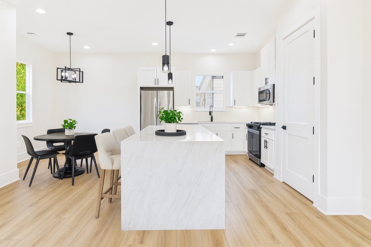 4506 Robertson Street Houston, TX 77009 - Photo 8 of 25 a kitchen with stainless steel appliances a table chairs refrigerator and sink