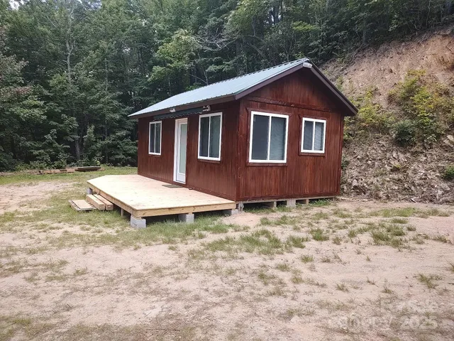 a backyard of a house with dishwasher and wooden fence