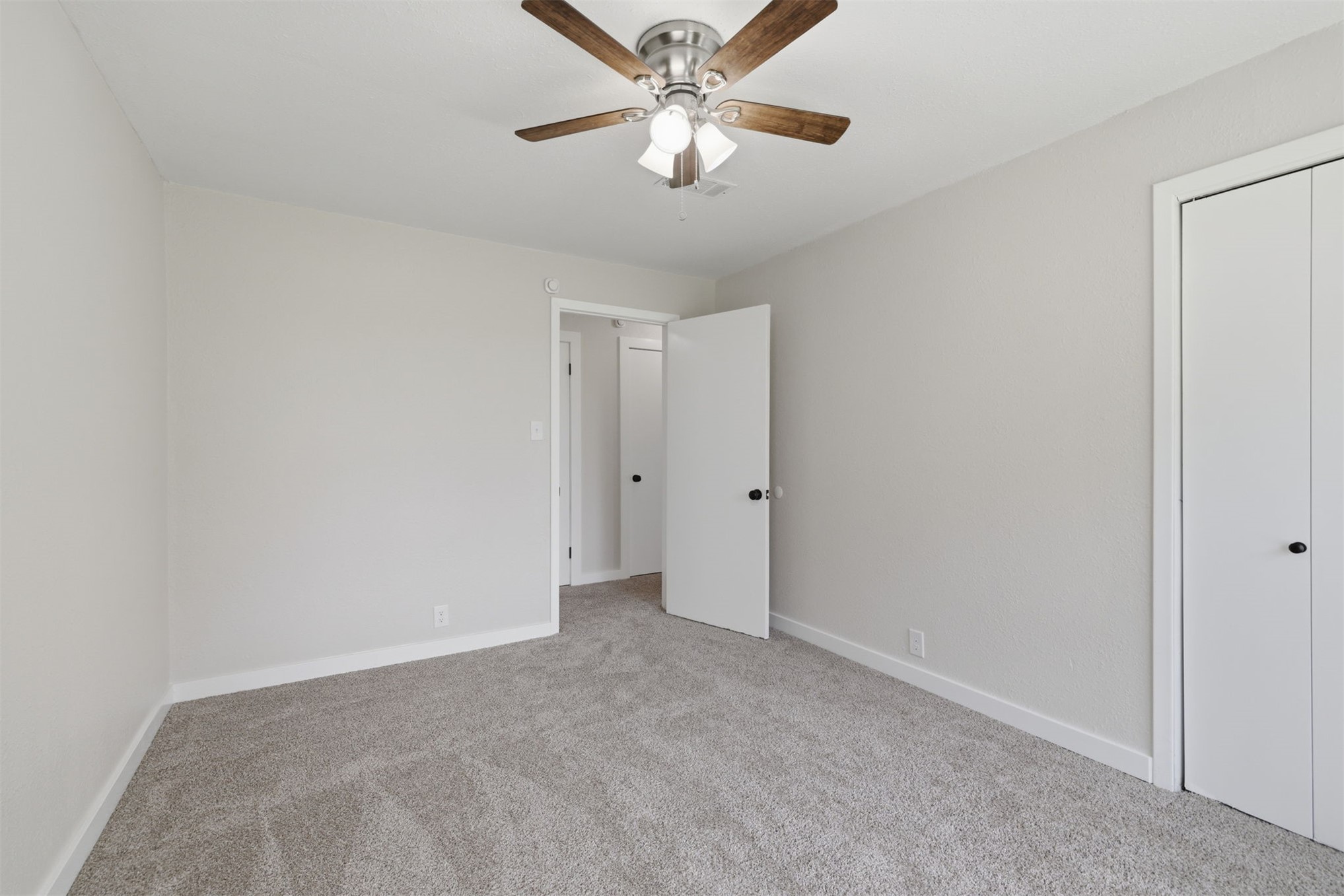 633 Swinney Road Mead, OK 73449 - Photo 11 of 32 Carpeted room featuring a ceiling fan with integrated lighting, a white painted door, and a bi-fold closet