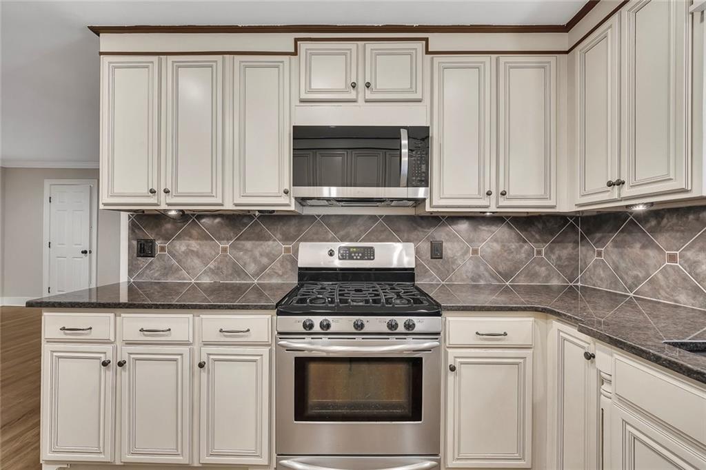 2290 Beaver Creek Road Smyrna, GA 30080 - Photo 16 of 66 a kitchen with granite countertop white cabinets and a stove top oven
