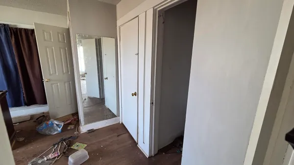 a view of a hallway with closet and wooden floor