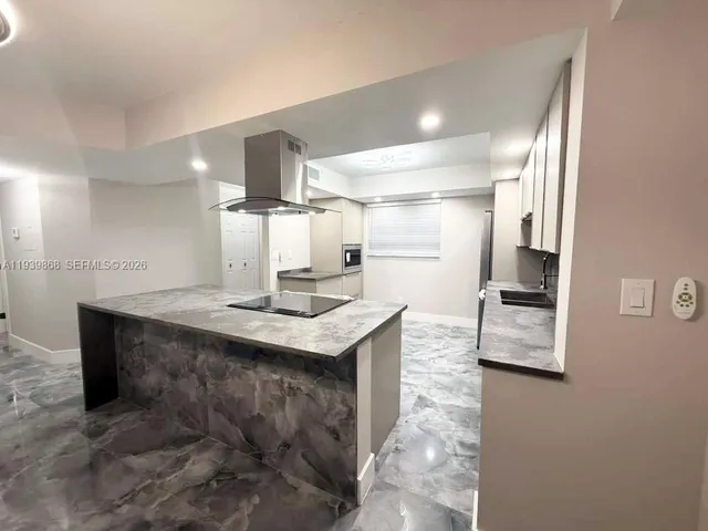 a kitchen with kitchen island a sink stainless steel appliances and cabinets