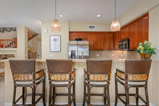 a kitchen with granite countertop a table chairs stove and a refrigerator