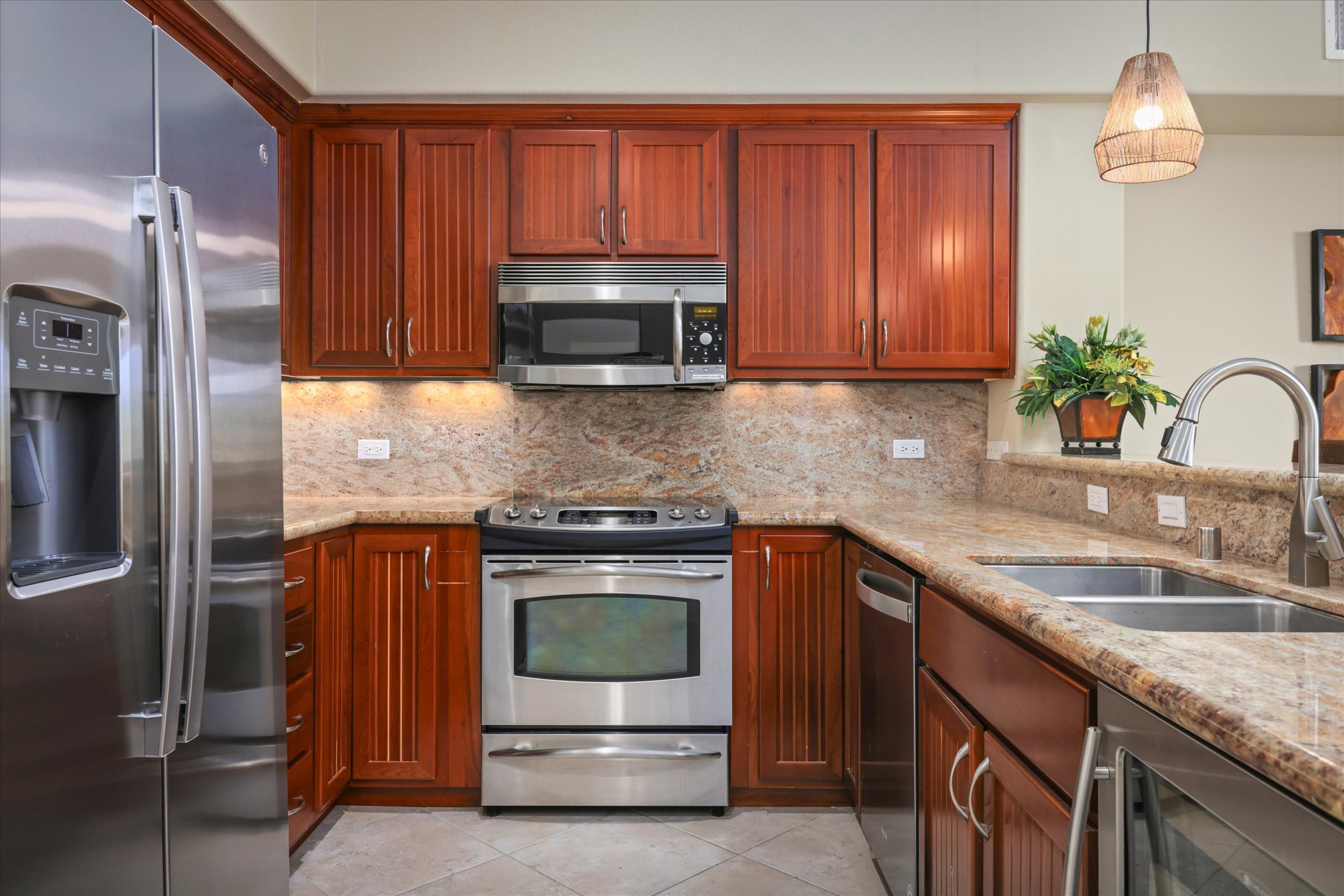 68-1122 Na Ala Hele Road, Unit G3 Kamuela, HI 96743 - Photo 12 of 30 a kitchen with granite countertop wooden cabinets and stainless steel appliances