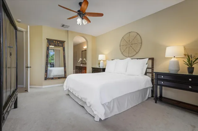 a bedroom with a bed mirror and a chandelier