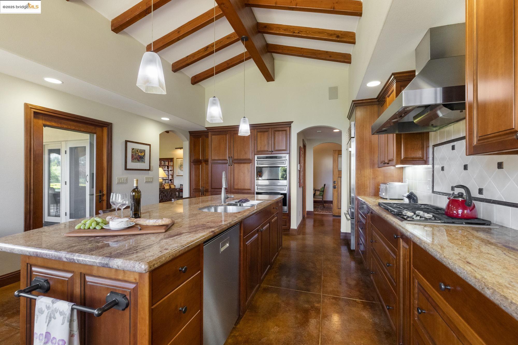 10270 Slate Rim Road Sonora, CA 95370 - Photo 16 of 55 a kitchen with stainless steel appliances granite countertop a lot of counter space and wooden floors
