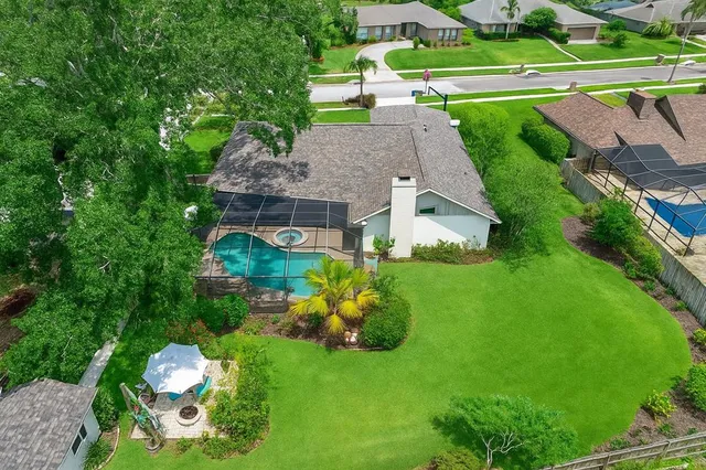 a aerial view of a house with a big yard and large trees
