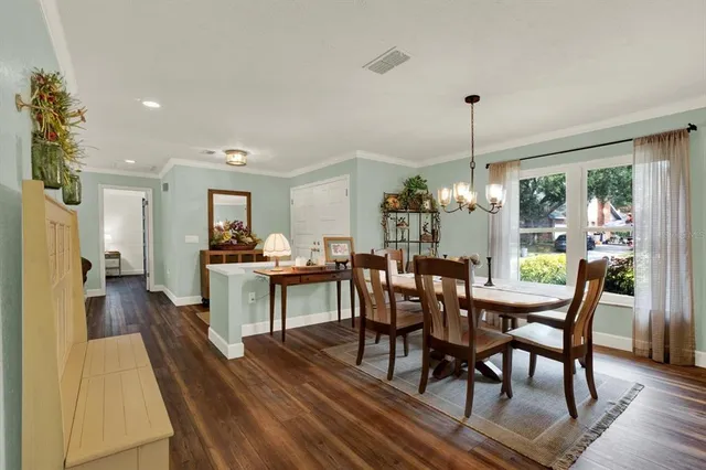 a view of a dining room and livingroom with furniture wooden floor a chandelier