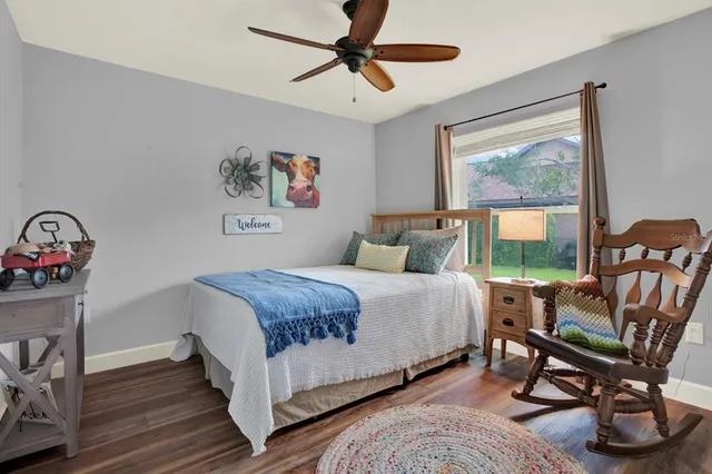 a bedroom with a bed a chair and a large window