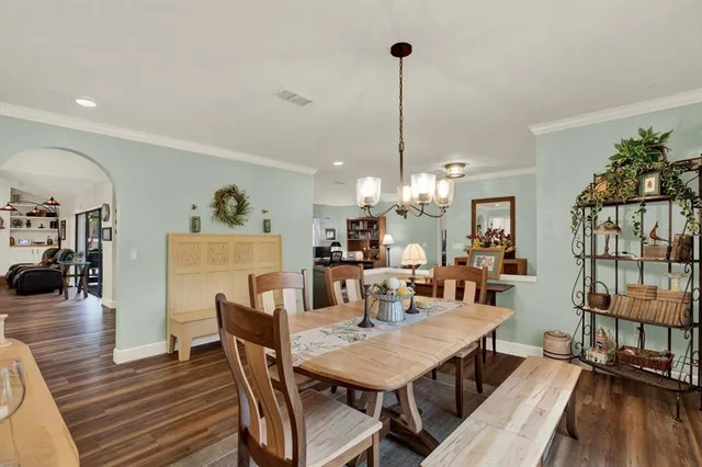 a view of a dining room and livingroom with furniture wooden floor a chandelier