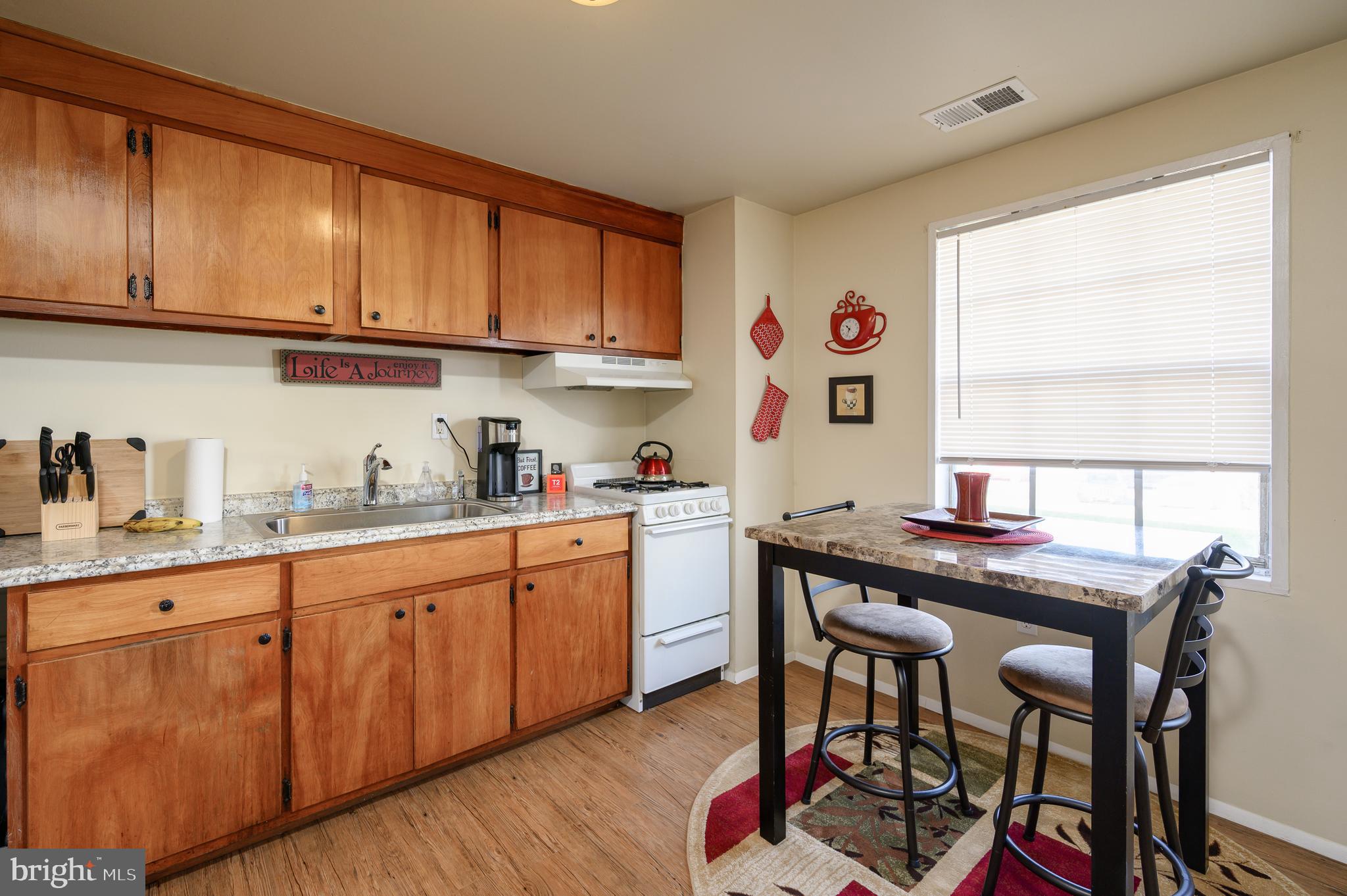 137 Roberta Jean Avenue Littlestown, PA 17340 - Photo 2 of 8 a kitchen with stainless steel appliances granite countertop a table chairs sink and cabinets