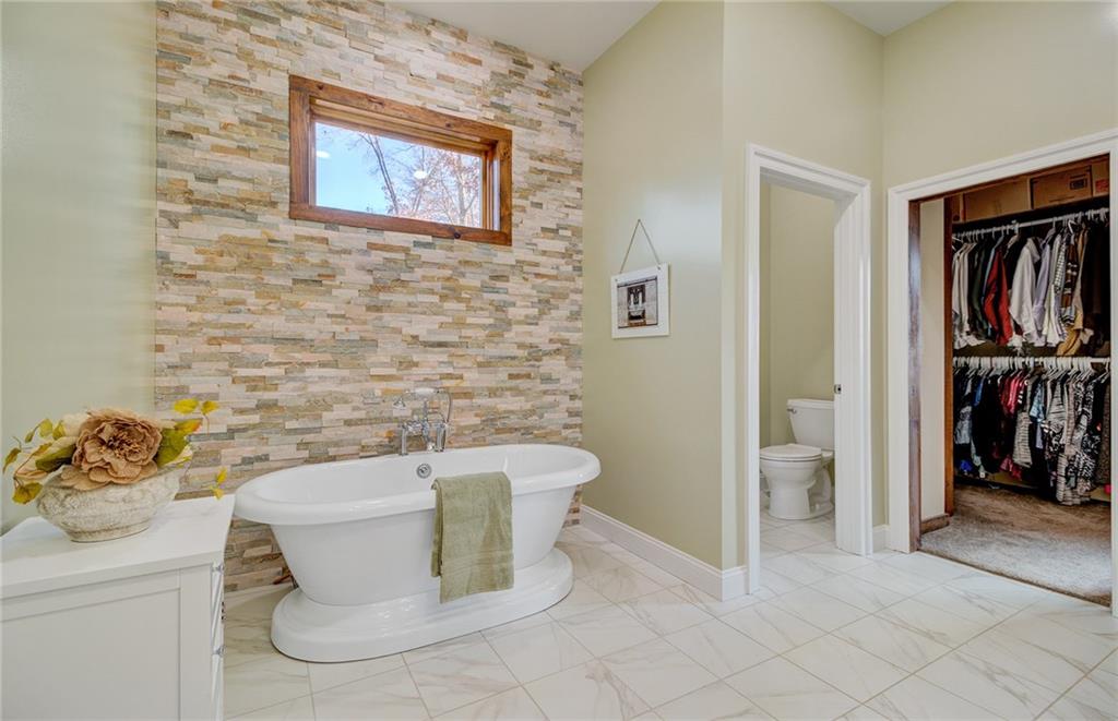 122 Klein Road Cranberry Township, PA 16066 - Photo 10 of 25 Full custom ensuite featuring tile flooring and ledge stone wall, soaking tub, private bath, extra large tile shower with custom in-lay. recessed lights and speakers, granite double bowl vanity and walk-in closet leading to the laundry room.