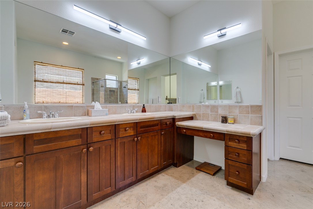 8 Kennesaw Road Henderson, NV 89052 - Photo 33 of 44 Double vanity and a dedicated makeup station elevate daily routines in this bathroom.