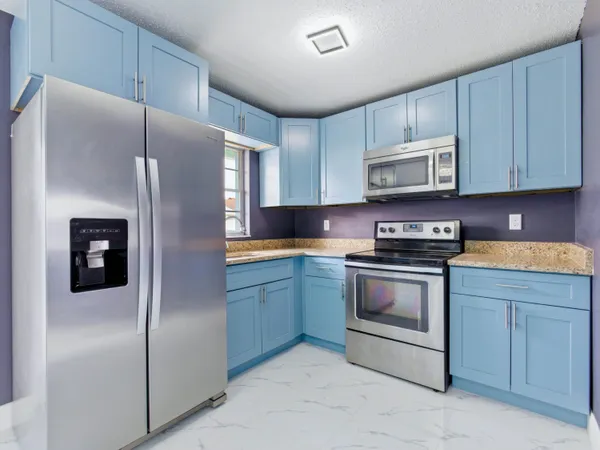 a kitchen with granite countertop a stove and a refrigerator