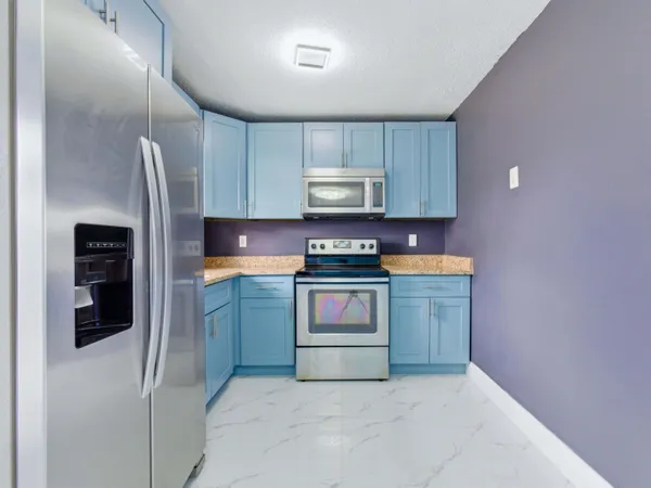 a kitchen with stainless steel appliances granite countertop a refrigerator and a sink