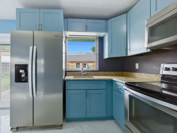 a kitchen with stainless steel appliances granite countertop a refrigerator and a sink