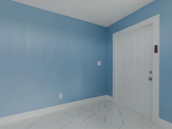 a view of an empty room with a chandelier fan