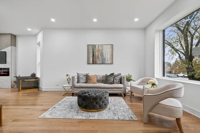 a living room with furniture a flat screen tv and a window