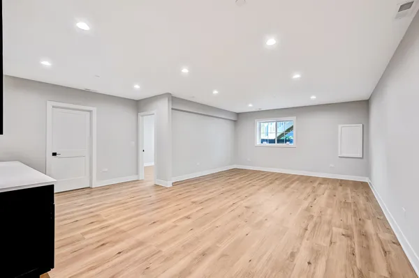 an empty room with wooden floor and fireplace