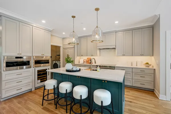 a kitchen with granite countertop white cabinets and chairs