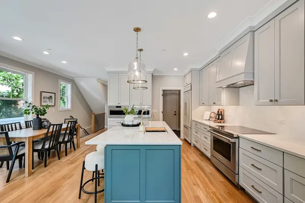 a kitchen with stainless steel appliances kitchen island granite countertop a stove a sink a refrigerator and chairs