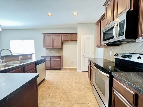a kitchen with stainless steel appliances granite countertop a sink and a stove