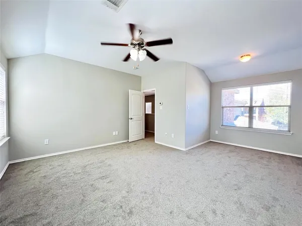 an empty room with windows and fan