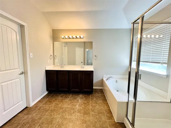 a bathroom with a tub sink and mirror