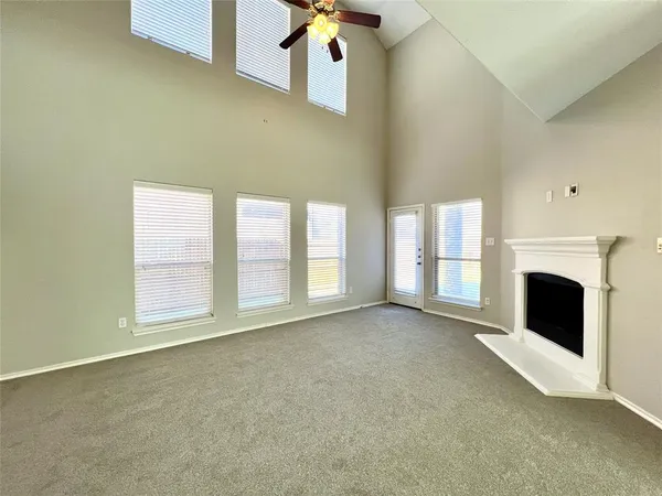a view of an empty room with a fireplace and a window