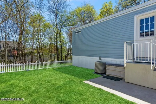 a view of a backyard with wooden fence and a bench