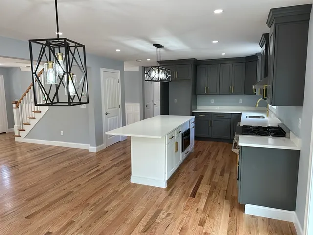 a kitchen with stainless steel appliances granite countertop a sink a stove and a refrigerator