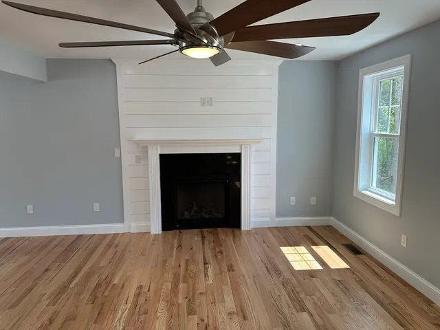 a view of empty room with window and wooden floor