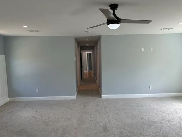en empty room with windows and ceiling fan