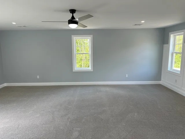 an empty room with a window and a ceiling fan