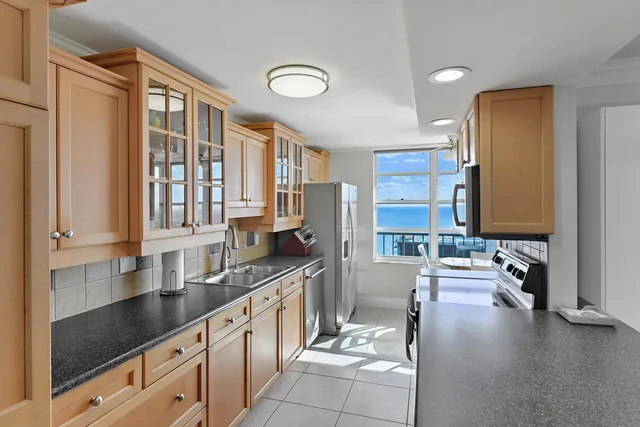 a large kitchen with stainless steel appliances a sink and cabinets