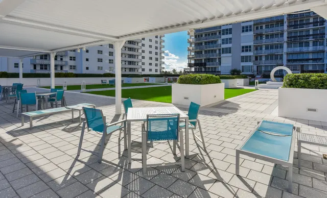 a view of a patio with a dining table and chairs with a fire pit