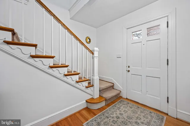 a view of a hallway with wooden floor and staircase