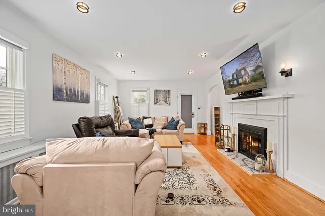 a view of a dining room and livingroom with furniture wooden floor a rug and a chandelier