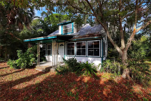 a front view of a house with a yard and potted plants