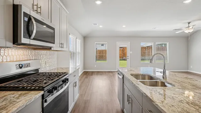 a kitchen that has a sink and a stove top oven