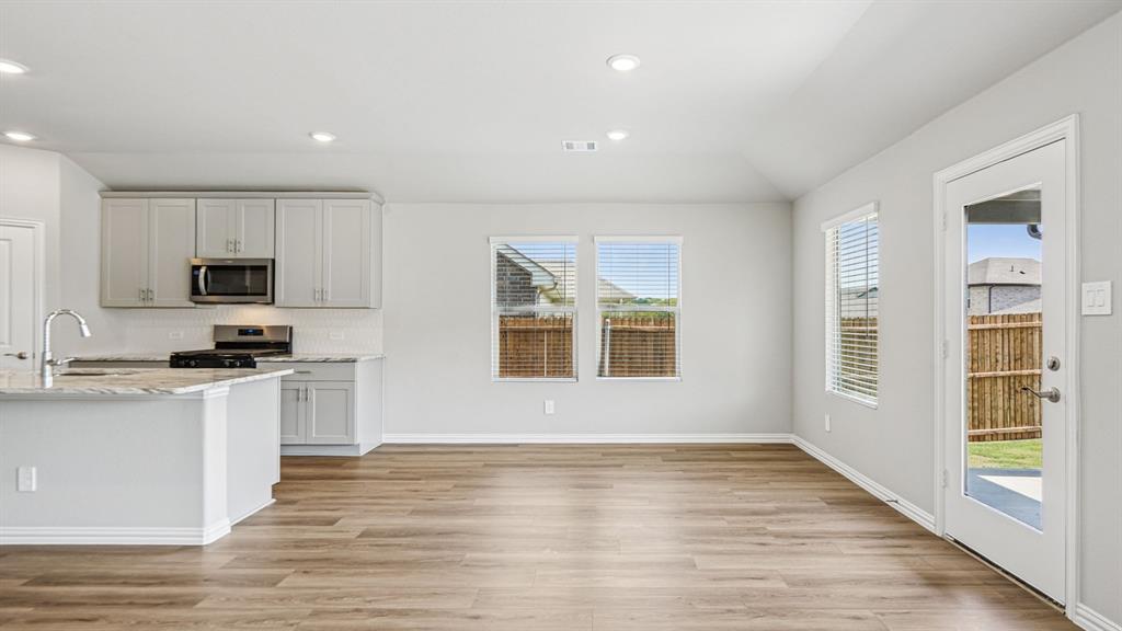 2120 Rannoch Street Sherman, TX 75092 - Photo 11 of 36 a kitchen with granite countertop a stove top oven sink and cabinets