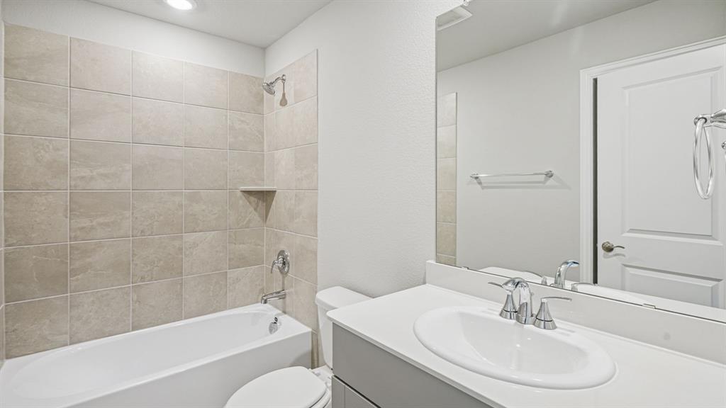 2120 Rannoch Street Sherman, TX 75092 - Photo 16 of 36 a bathroom with a bathtub a sink a toilet and a mirror