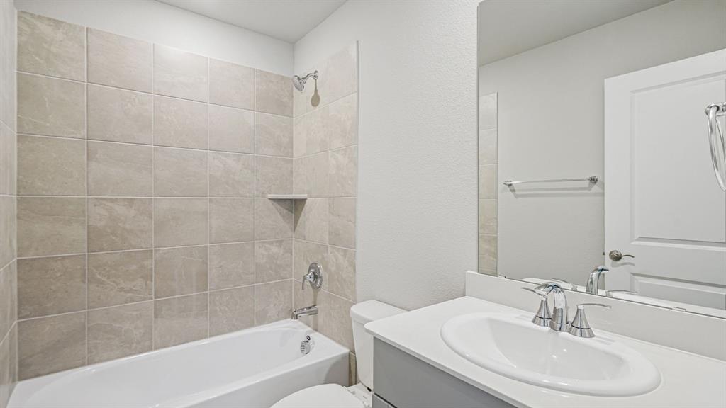 2120 Rannoch Street Sherman, TX 75092 - Photo 26 of 36 a bathroom with a bathtub a sink a toilet and a mirror