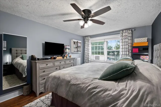 a bedroom with a bed and a flat tv screen on dresser