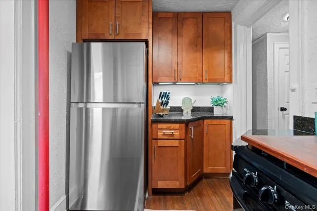 a kitchen with stainless steel appliances granite countertop a refrigerator and a stove top oven