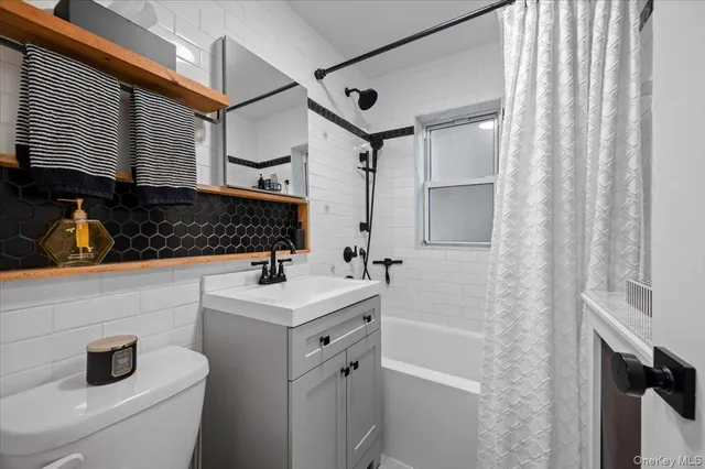 a bathroom with a sink toilet vanity and shower