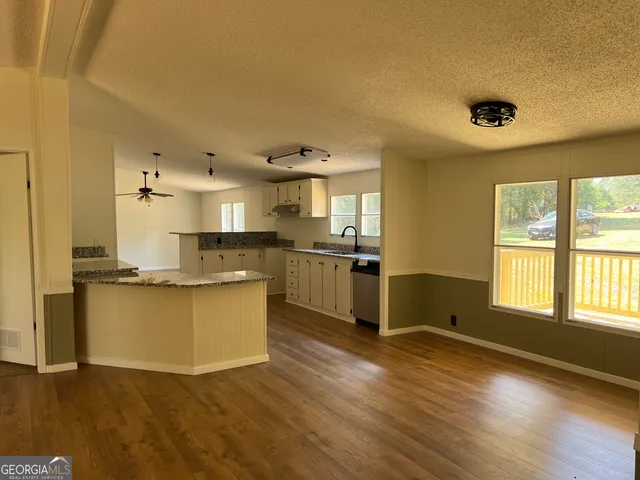 a kitchen with stainless steel appliances granite countertop a sink and a wooden floors